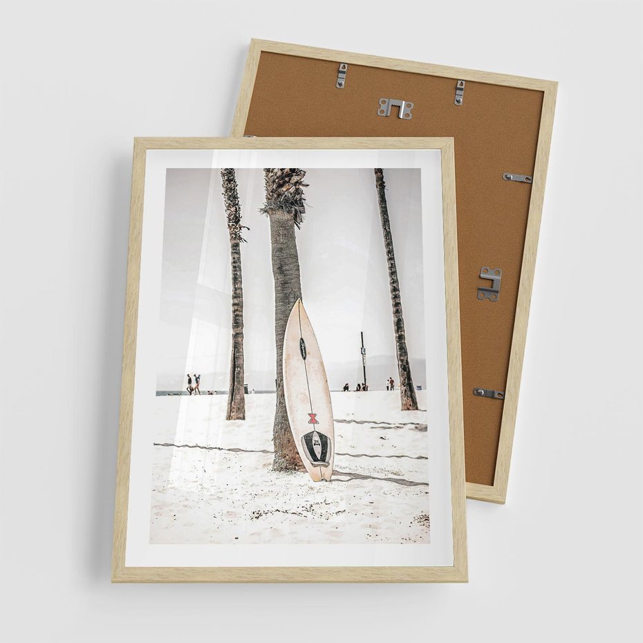 Plakat w ramie 50x70 - Plażowy Relaks - deska surfingowa, oparta o palmę - rama drewno