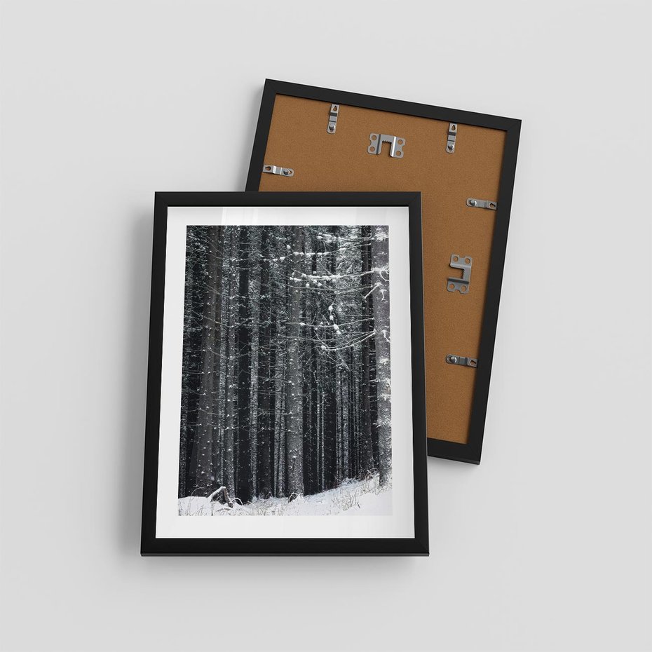 Plakat w ramie 30x40 - Leśna Cisza: Malowniczy Pejzaż Zimą - las zimą, ośnieżone pnie drzew - rama czarna