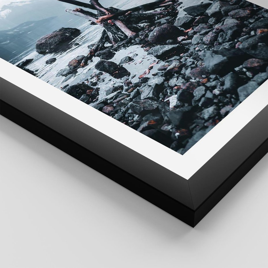 Plakat w ramie 30x40 - To ujęcie jeziora w górach z zgaszonym ogniskiem nad brzegiem, tworząc atmosferę spokoju i refleksji w otoczeniu przyrody. - jezioro w górach, zgaszone ognisko - rama czarna