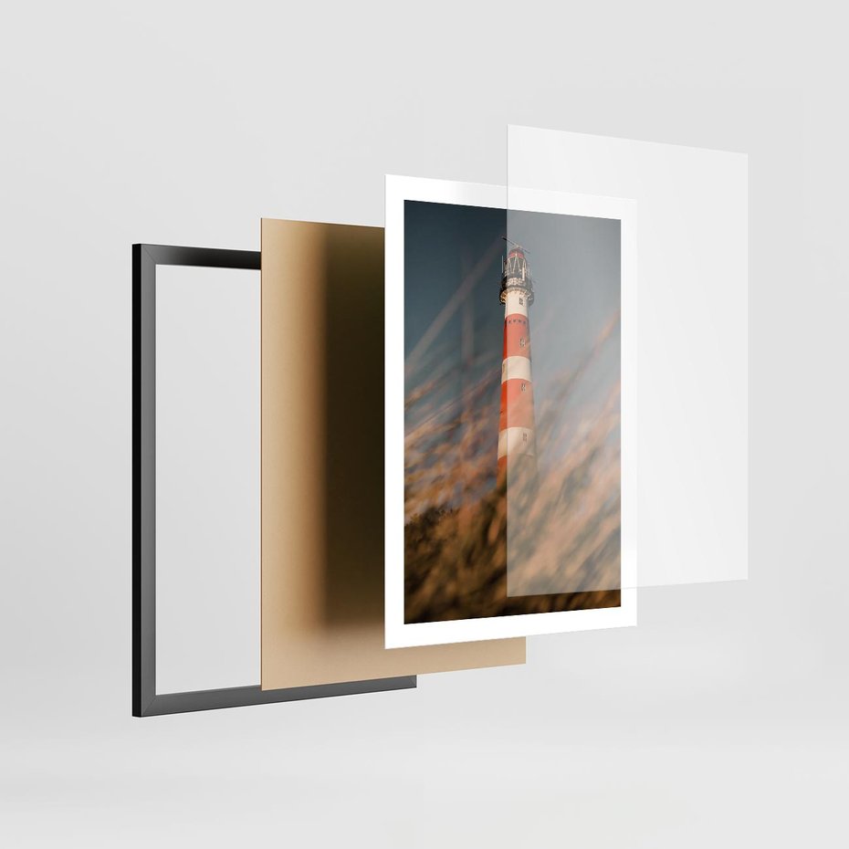 Plakat w ramie 50x70 - Magia nadmorskiego światła - latarnia morska, ujęcie z za trawy - rama czarna
