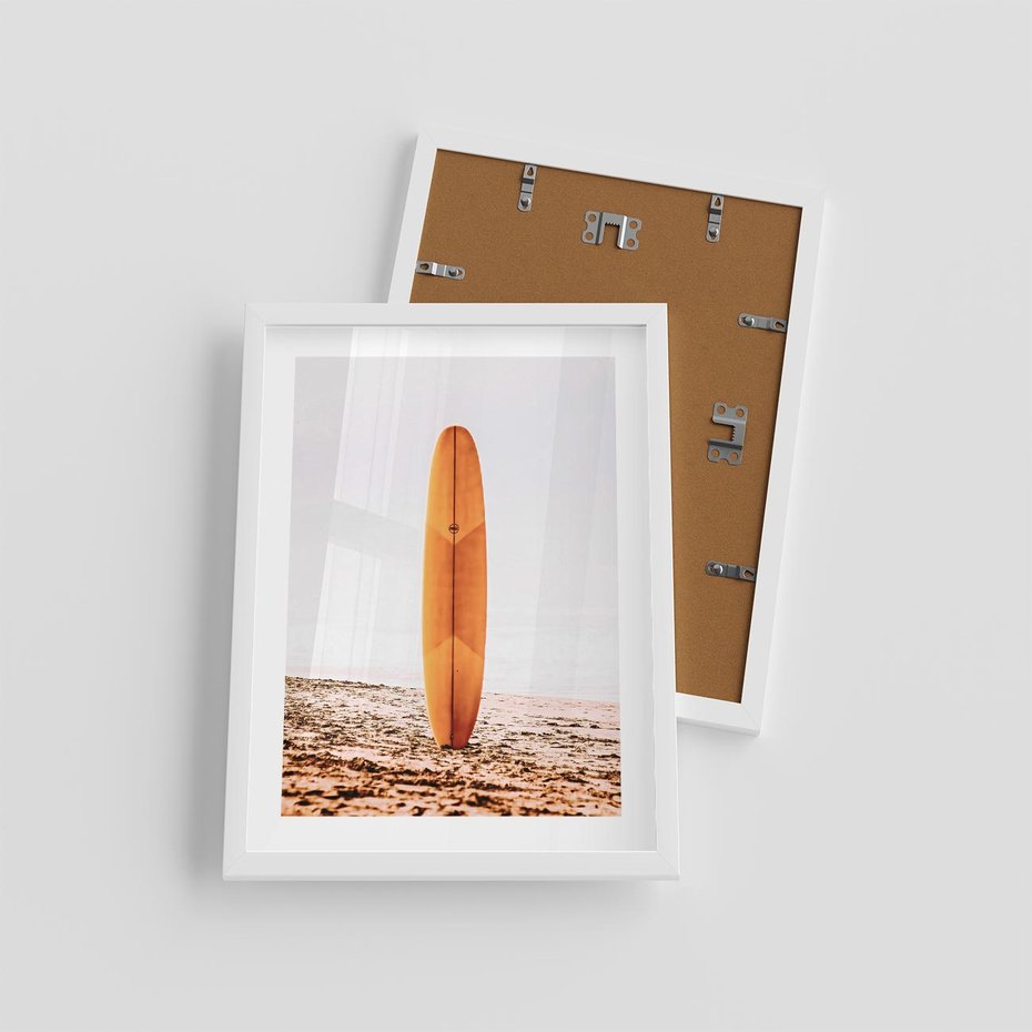 Plakat w ramie 30x40 - Deska w Piasku: Gotowa na Fale - plaża, pomarańczowa deska surfingowa wbita w piasek - rama biała