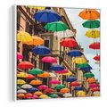 Obraz w ramie 50x50 - Barwna symfonia wyobraźni - fotografia, kolorowe parasolki podwieszone nad ulicą - rama biała