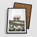 Plakat w ramie 50x70 - Krajobraz z Przeszłości: Kwitnąca Łąka w Sepii - domek na wzgórzu, kwitnąca łąka - rama czarna