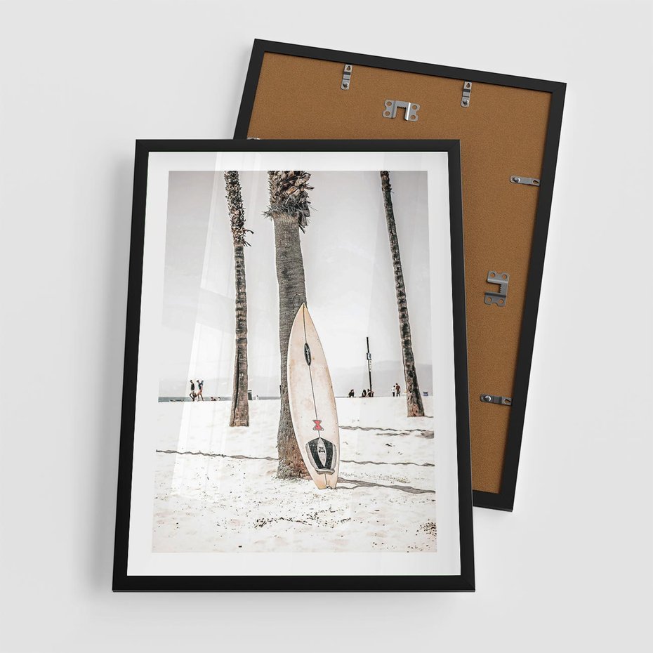 Plakat w ramie 50x70 - Plażowy Relaks - deska surfingowa, oparta o palmę - rama czarna