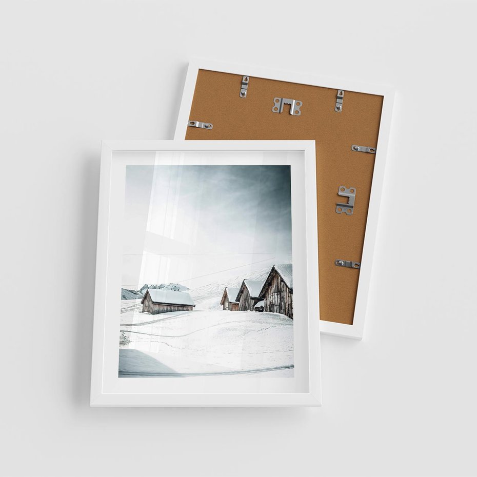 Plakat w ramie 40x50 - Zima w Domkach: Urok Śnieżnej Scenerii - domki w śnieżnym krajobrazie - rama biała