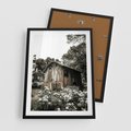 Plakat w ramie 50x70 - Oaza Uroku: Drewniana Chatka i Ogród - domek, ogród - rama czarna