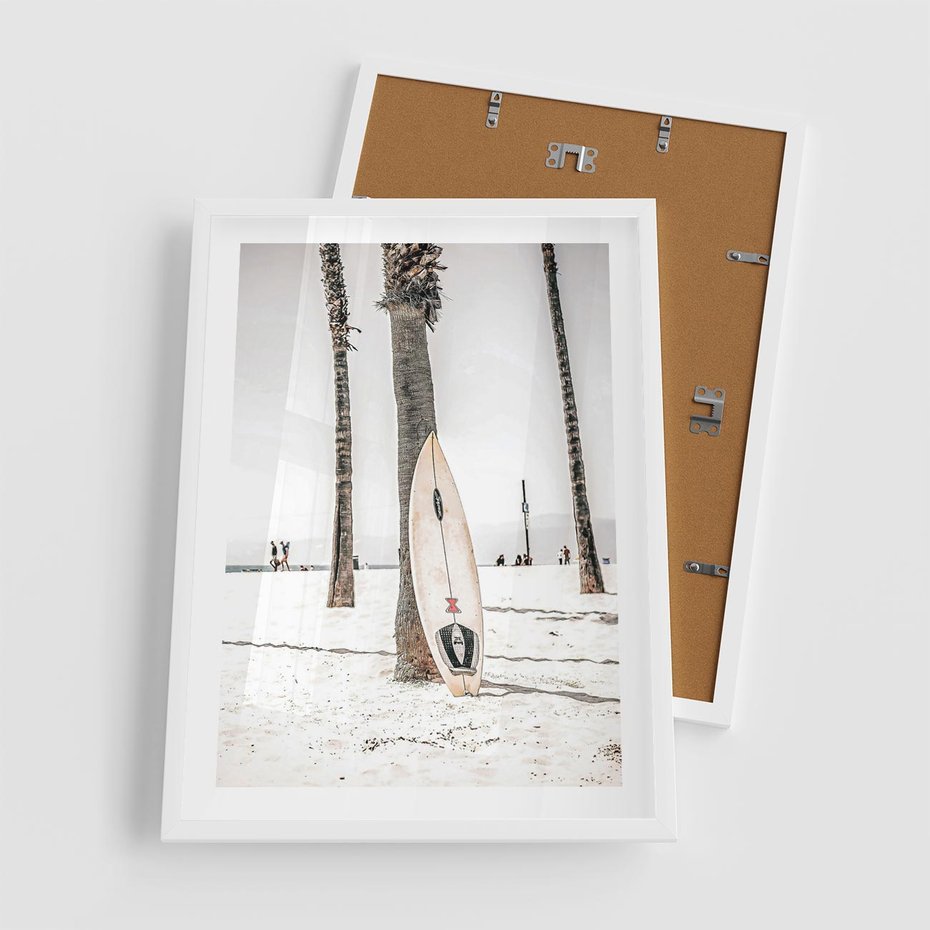 Plakat w ramie 50x70 - Plażowy Relaks - deska surfingowa, oparta o palmę - rama biała