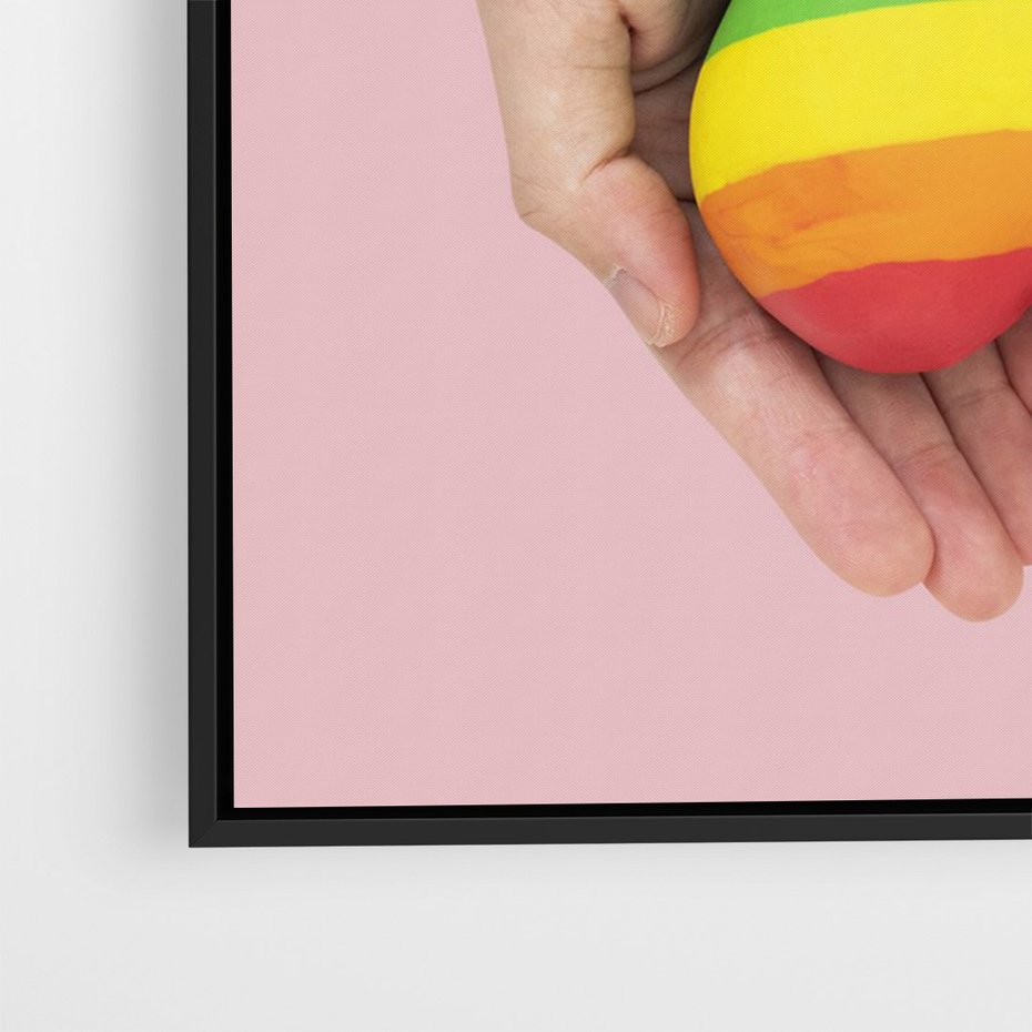 Obraz w ramie 70x100 - Miłość na Dłoniach - zdjęcie, dłonie trzymają ulepione tęczowe serce - rama czarna