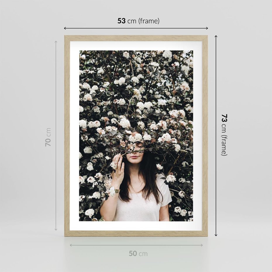 Plakat w ramie 50x70 - Kobieta w Krzewie Kwiatów - krzak z kwiatami, schowana za nim kobieta - rama drewno