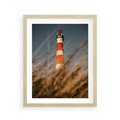 Plakat w ramie 40x50 - Magia nadmorskiego światła - latarnia morska, ujęcie z za trawy - rama drewno