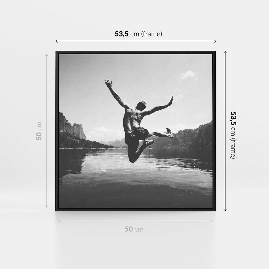 Obraz w ramie 50x50 - Beztroska Chwila - czarno biała fotografia, mężczyzna wesoło wskakuje do keziora w górach - rama czarna