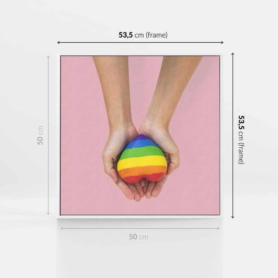 Obraz w ramie 50x50 - Miłość na Dłoniach - zdjęcie, dłonie trzymają ulepione tęczowe serce - rama biała