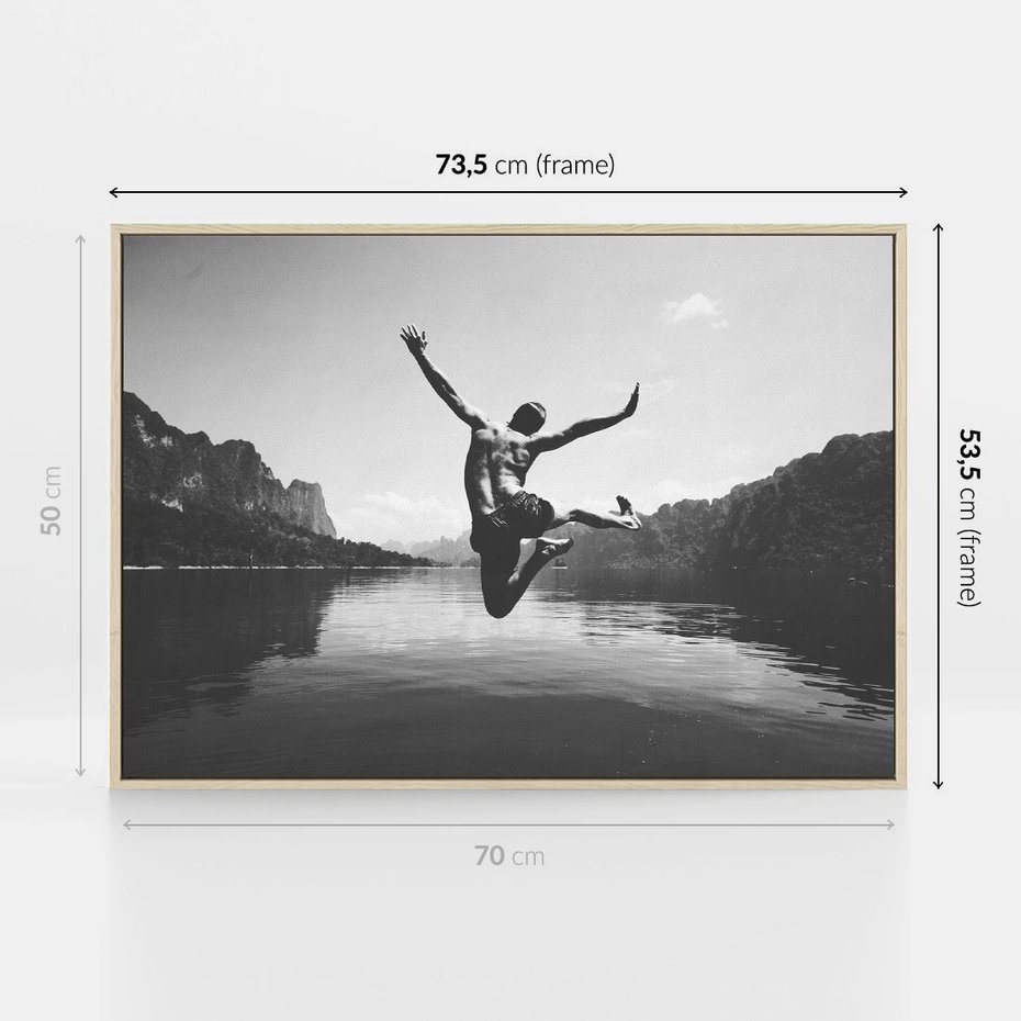 Obraz w ramie 70x50 - Beztroska Chwila - czarno biała fotografia, mężczyzna wesoło wskakuje do keziora w górach - rama drewno