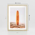 Plakat w ramie 30x40 - Deska w Piasku: Gotowa na Fale - plaża, pomarańczowa deska surfingowa wbita w piasek - rama drewno