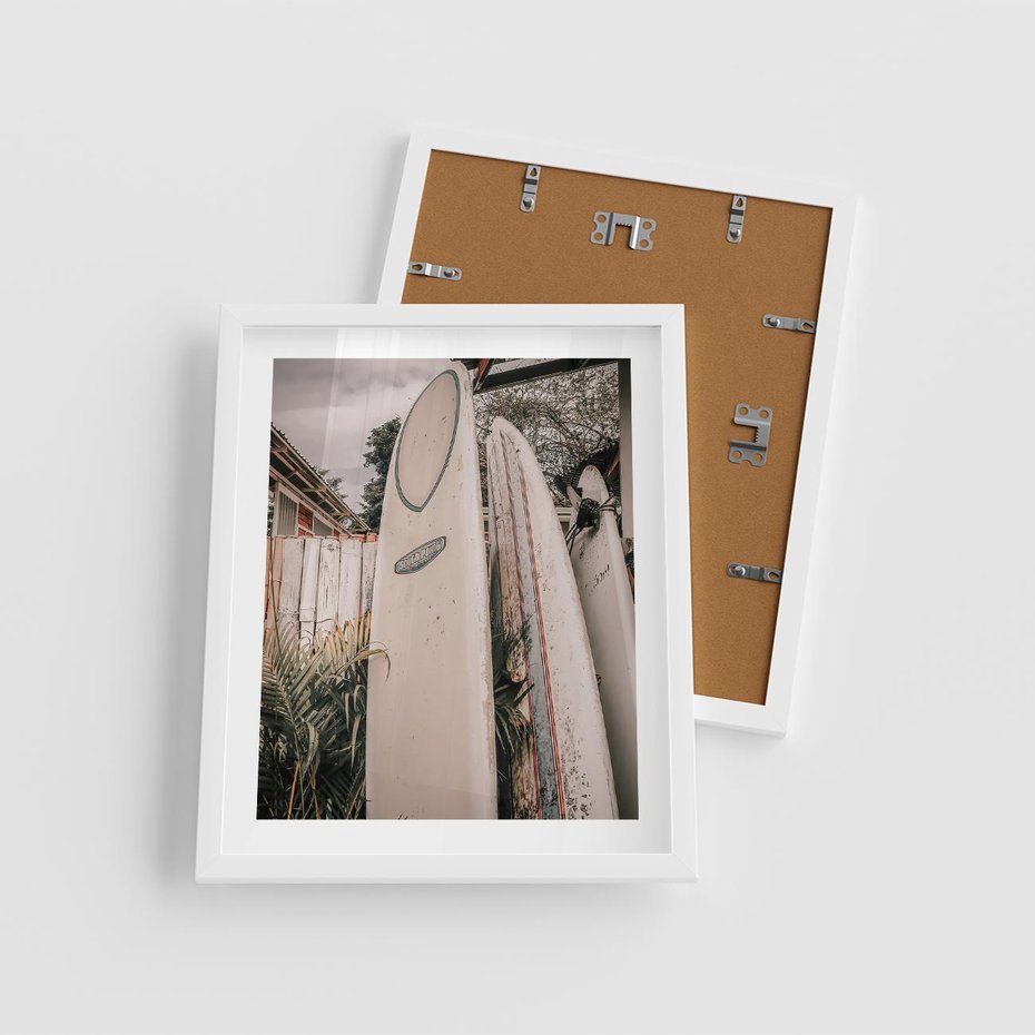 Plakat w ramie 40x50 - Deski Surfingowe czekają na Fale - deski surfingowe, stoją pod płotem - rama biała