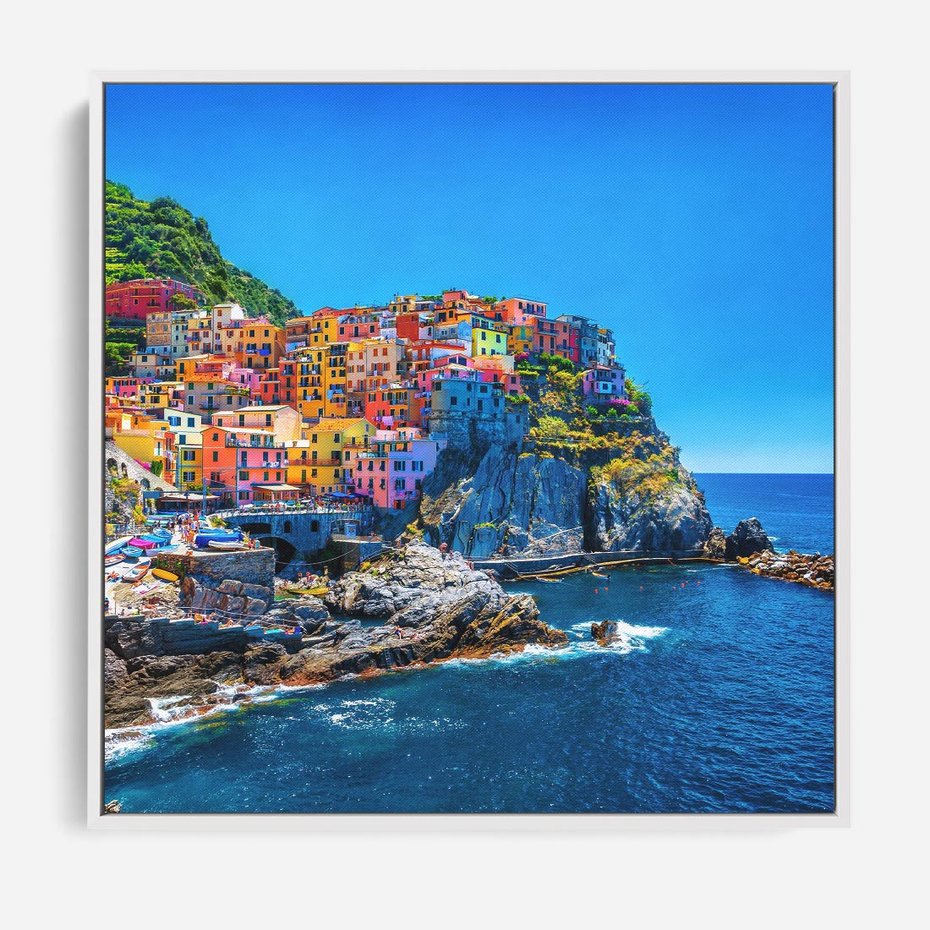 Obraz w ramie 50x50 - Barwne Wybrzeże - nadmorskie miasto na klifie, kolorowe tęczowe budynki - rama biała