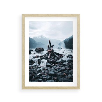 Plakat w ramie 50x70 - To ujęcie jeziora w górach z zgaszonym ogniskiem nad brzegiem, tworząc atmosferę spokoju i refleksji w otoczeniu przyrody. - jezioro w górach, zgaszone ognisko - rama drewno