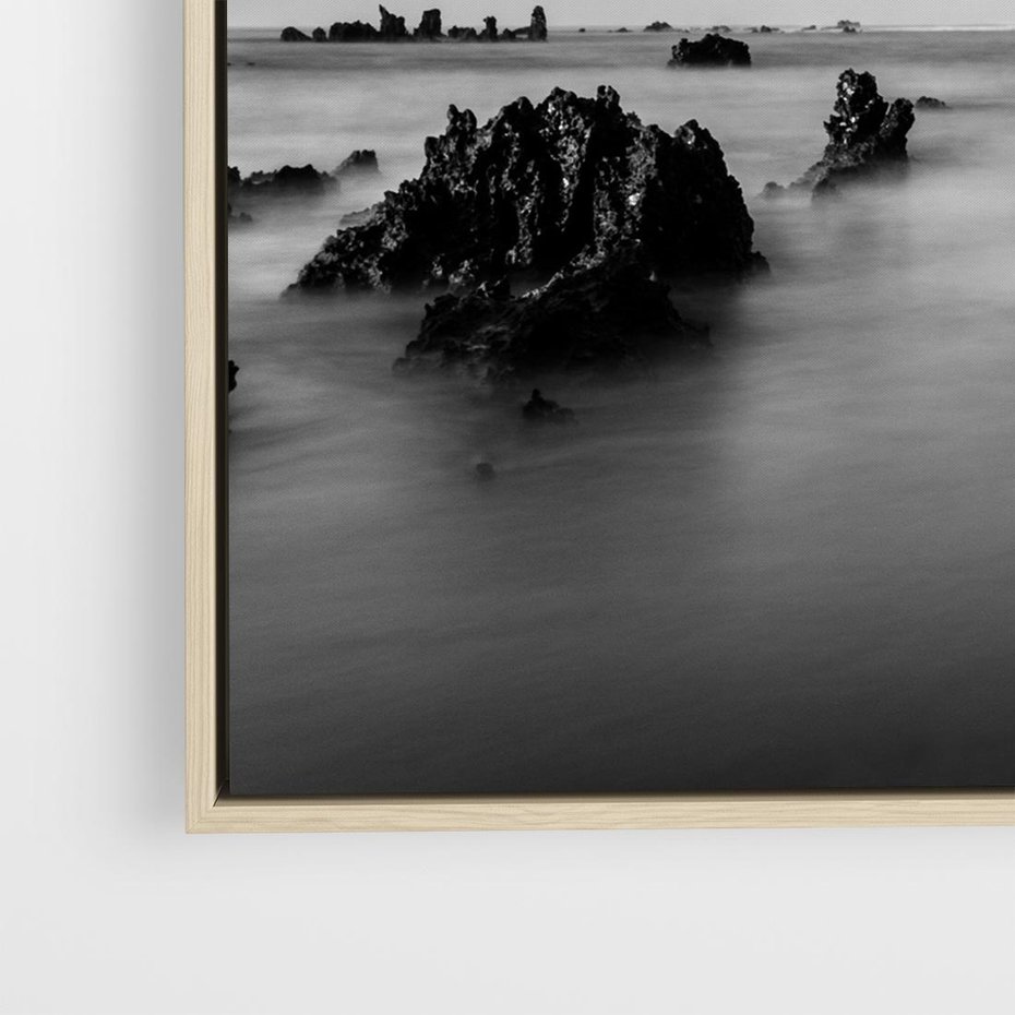 Obraz w ramie 50x50 - Harmonia świateł i cieni - zamglona dzika plaża, skały na plaży - rama drewno
