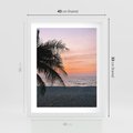 Plakat w ramie 40x50 - Tropikalny Zachód Słońca: Piękno Palmy - palma, nad morzem - rama biała