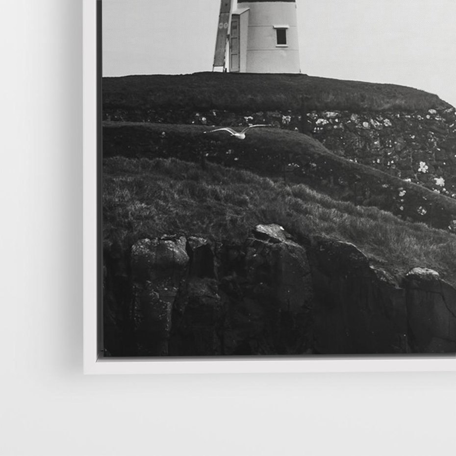 Obraz w ramie 70x50 - Melancholia Północy - czarnobiała fotografia, nadmorska latarnia na klifie - rama biała