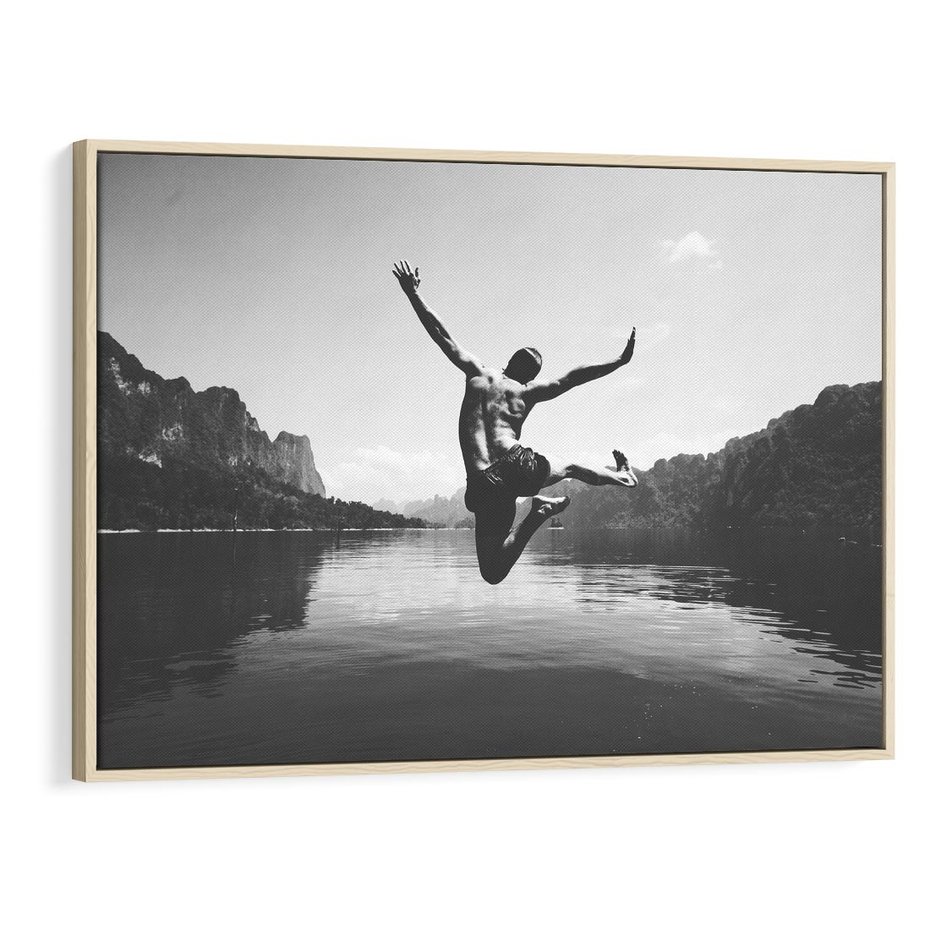 Obraz w ramie 100x70 - Beztroska Chwila - czarno biała fotografia, mężczyzna wesoło wskakuje do keziora w górach - rama drewno