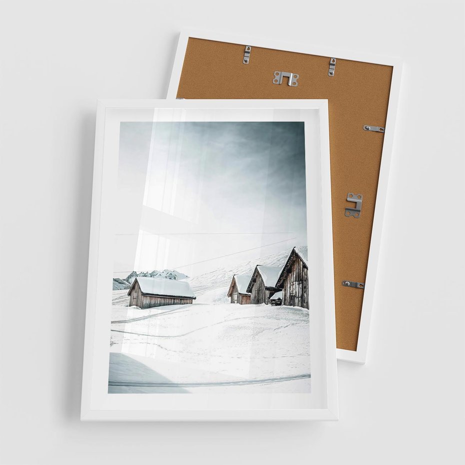 Plakat w ramie 50x70 - Zima w Domkach: Urok Śnieżnej Scenerii - domki w śnieżnym krajobrazie - rama biała