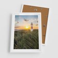 Plakat w ramie 50x70 - Magia latarni przy zachodzie - latarnia, zachód - rama biała
