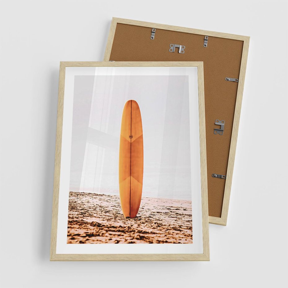 Plakat w ramie 50x70 - Deska w Piasku: Gotowa na Fale - plaża, pomarańczowa deska surfingowa wbita w piasek - rama drewno