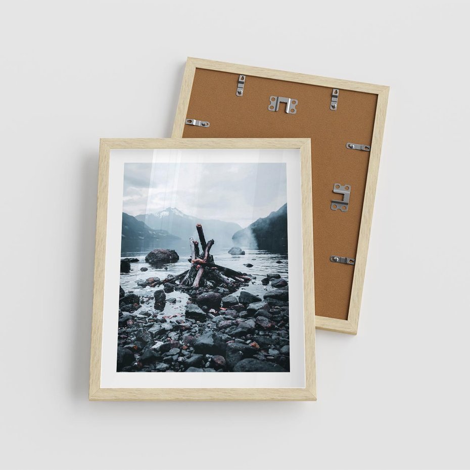 Plakat w ramie 40x50 - To ujęcie jeziora w górach z zgaszonym ogniskiem nad brzegiem, tworząc atmosferę spokoju i refleksji w otoczeniu przyrody. - jezioro w górach, zgaszone ognisko - rama drewno