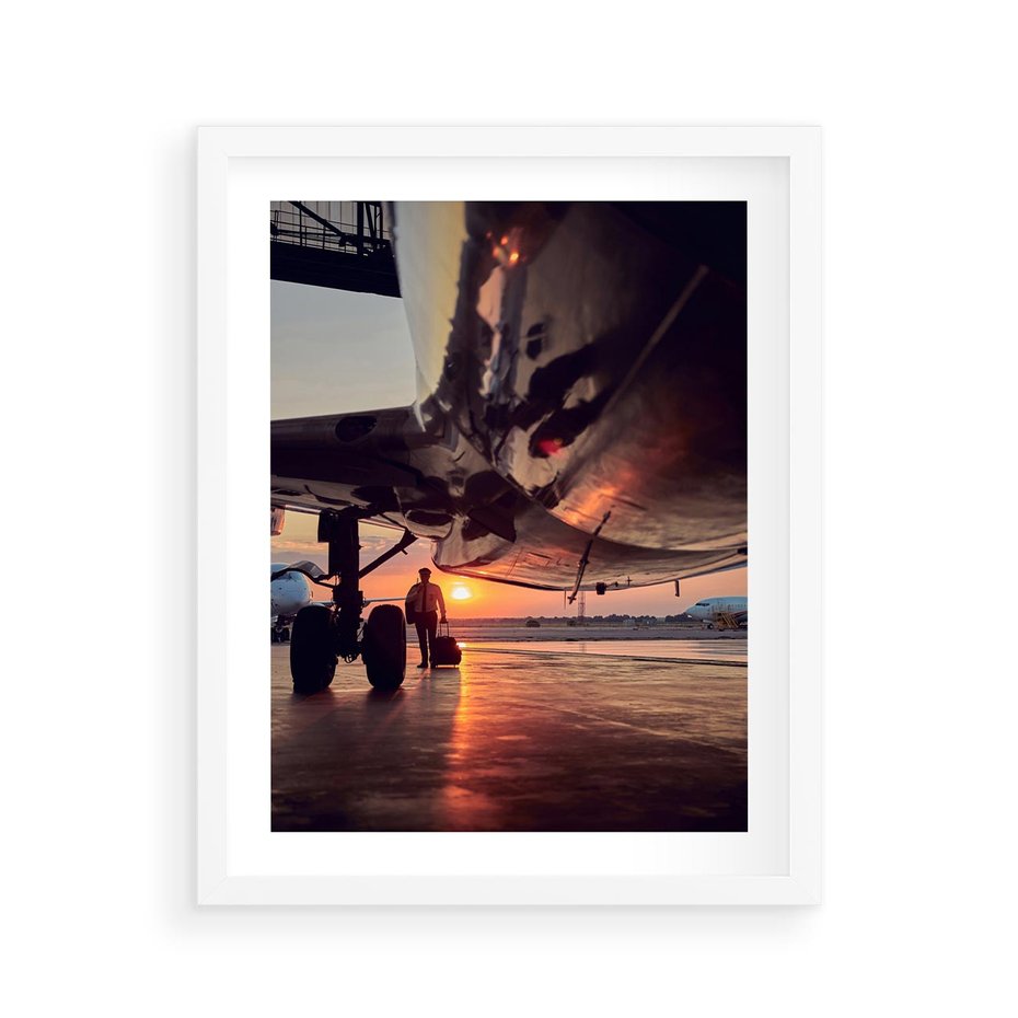 Plakat w ramie 40x50 - Podróż ku Zachodzącemu Słońcu - samolot, scena na lotnisku - rama biała