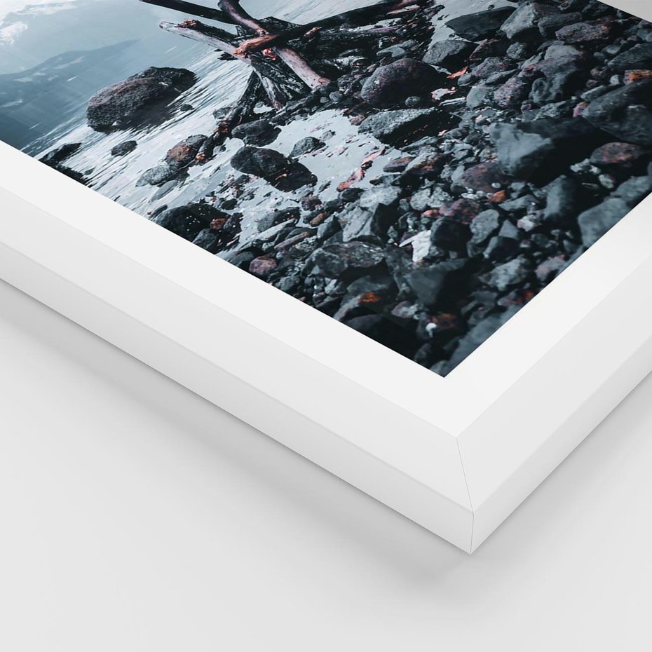 Plakat w ramie 50x70 - To ujęcie jeziora w górach z zgaszonym ogniskiem nad brzegiem, tworząc atmosferę spokoju i refleksji w otoczeniu przyrody. - jezioro w górach, zgaszone ognisko - rama biała