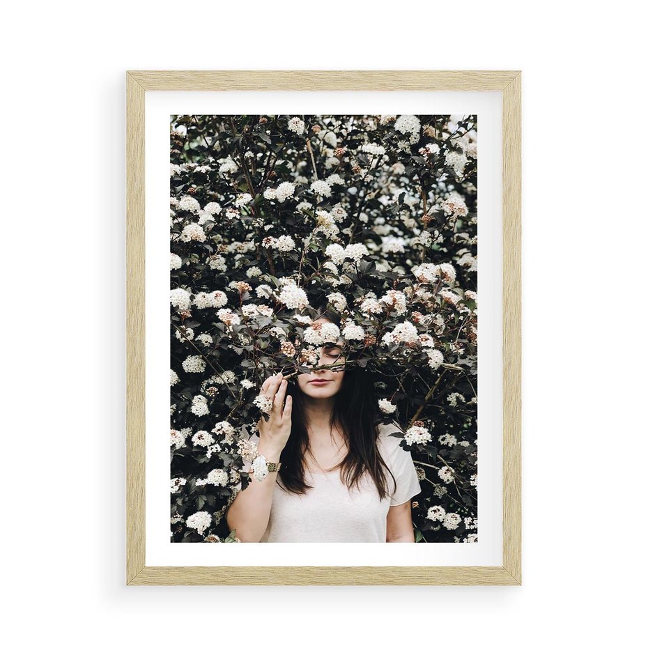 Plakat w ramie 50x70 - Kobieta w Krzewie Kwiatów - krzak z kwiatami, schowana za nim kobieta - rama drewno