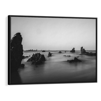 Obraz w ramie 100x70 - Harmonia świateł i cieni - zamglona dzika plaża, skały na plaży - rama czarna