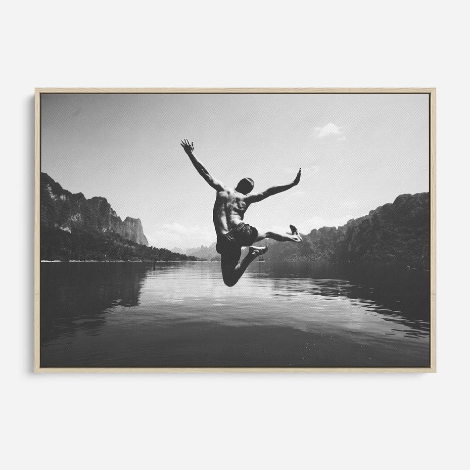 Obraz w ramie 70x50 - Beztroska Chwila - czarno biała fotografia, mężczyzna wesoło wskakuje do keziora w górach - rama drewno