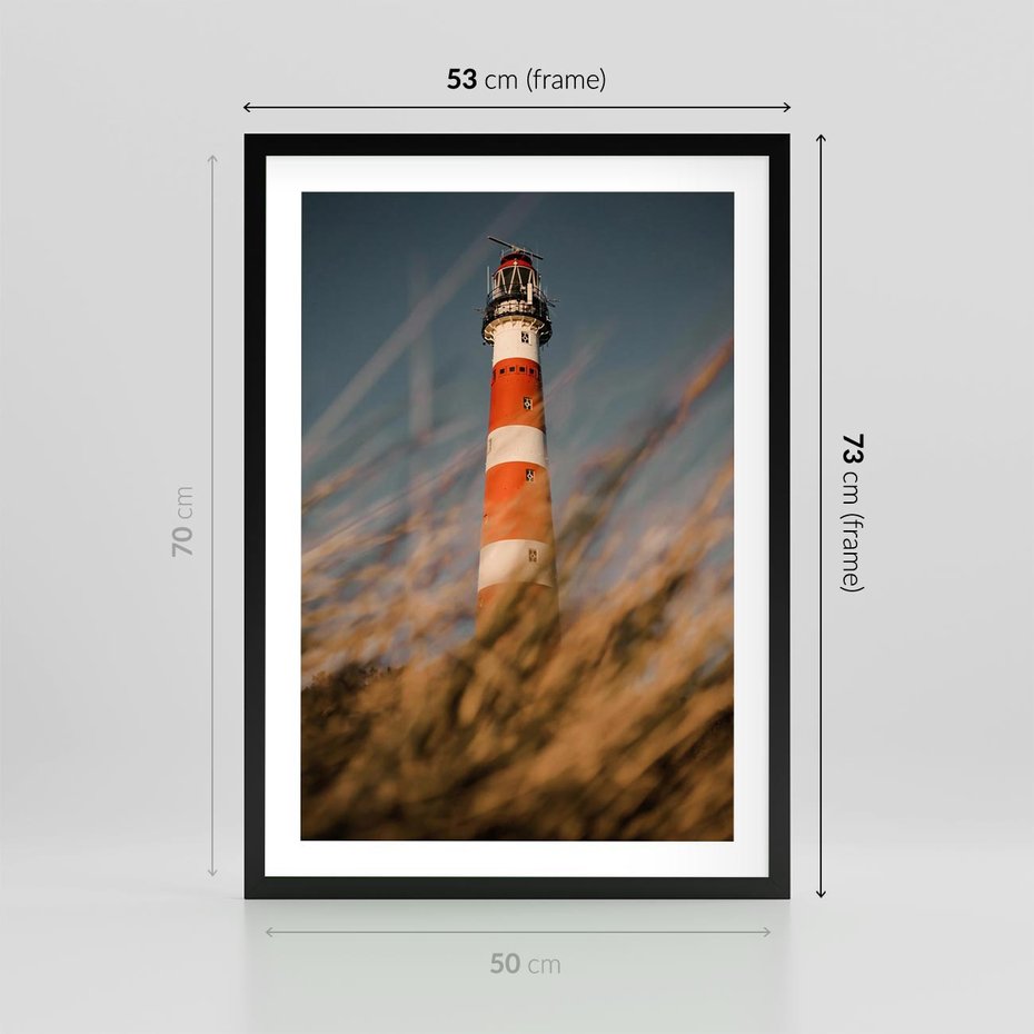 Plakat w ramie 50x70 - Magia nadmorskiego światła - latarnia morska, ujęcie z za trawy - rama czarna