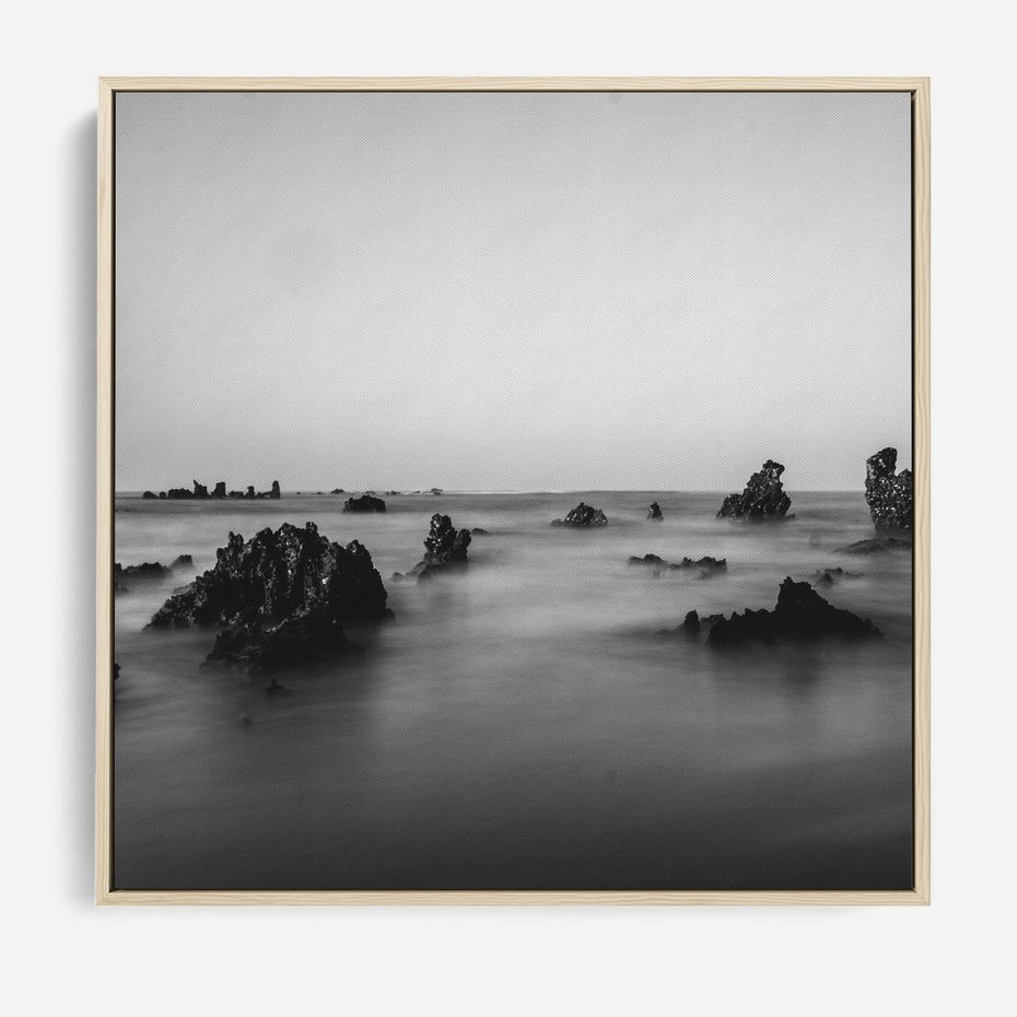 Obraz w ramie 80x80 - Harmonia świateł i cieni - zamglona dzika plaża, skały na plaży - rama drewno