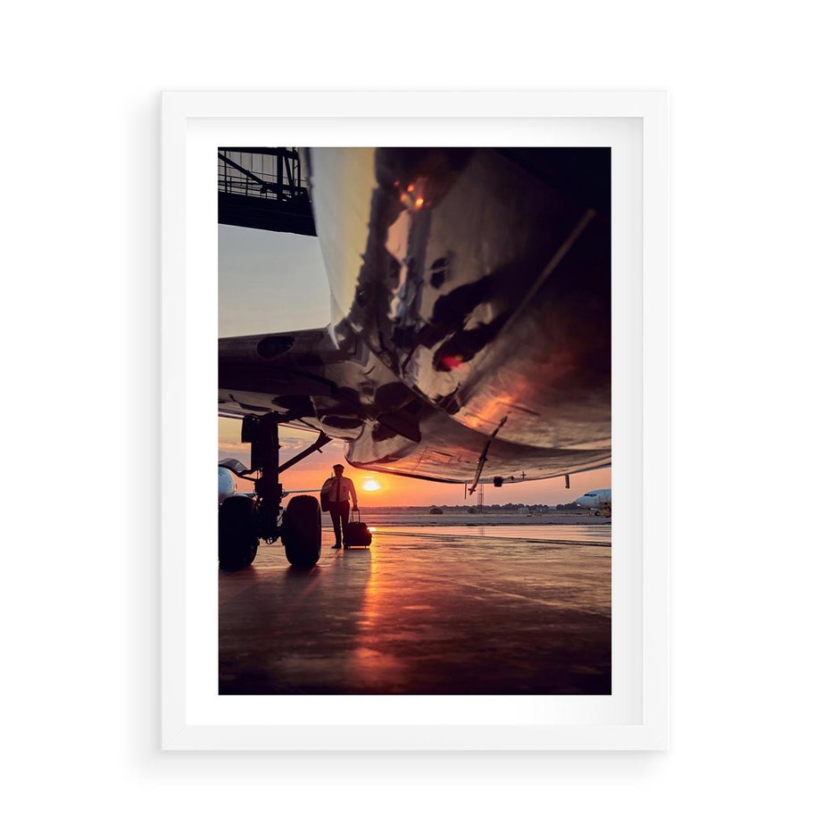 Plakat w ramie 50x70 - Podróż ku Zachodzącemu Słońcu - samolot, scena na lotnisku - rama biała