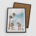 Plakat w ramie 50x70 - Tropikalna Sielskość: Palmy i Błękitne Niebo - palmy na tle błękitnego nieba - rama czarna