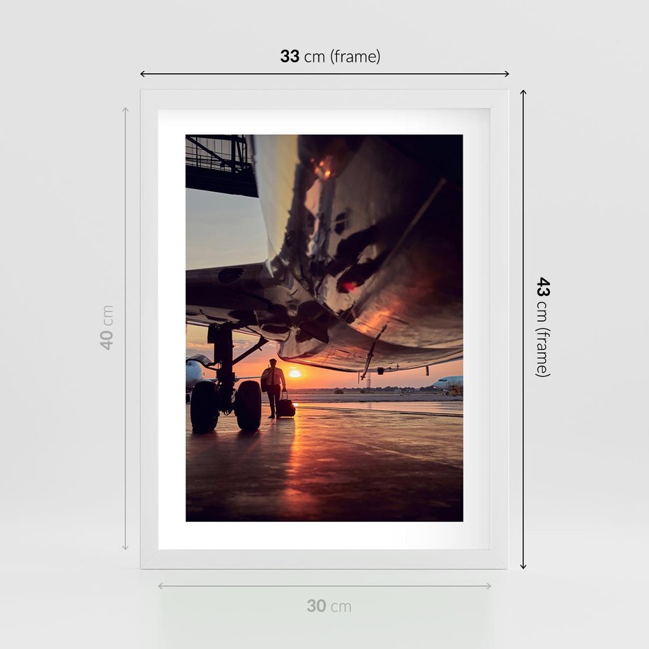 Plakat w ramie 30x40 - Podróż ku Zachodzącemu Słońcu - samolot, scena na lotnisku - rama biała