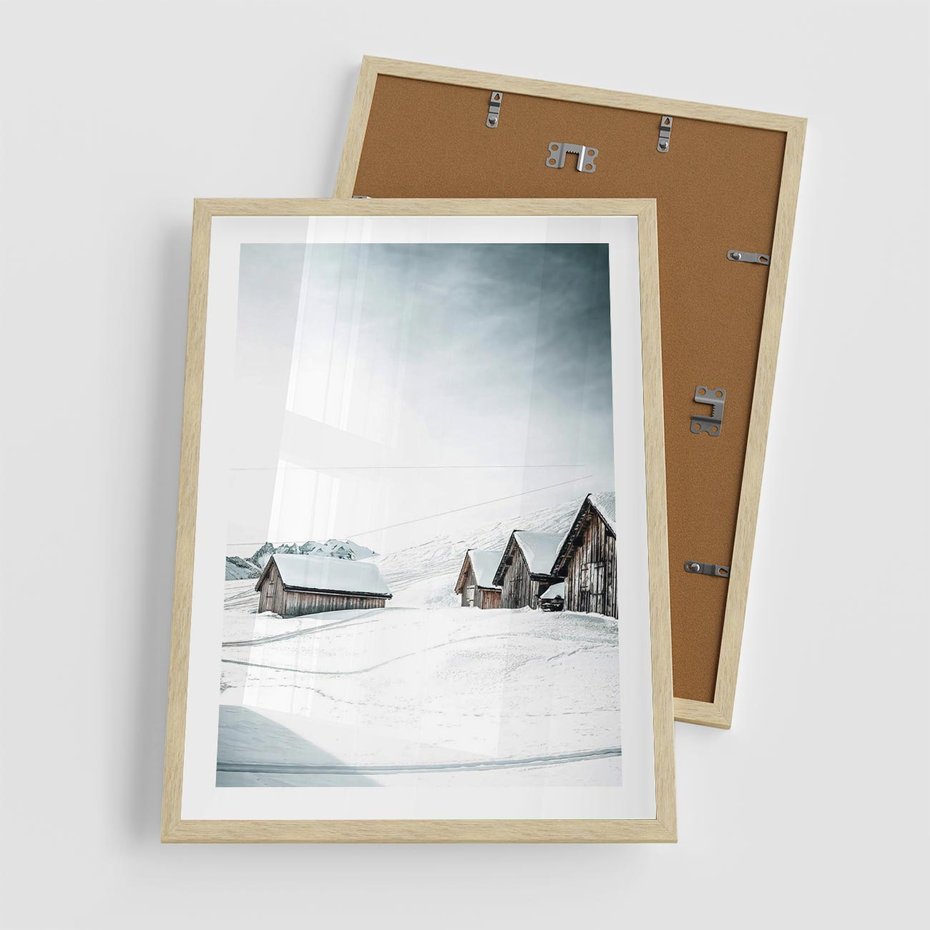 Plakat w ramie 50x70 - Zima w Domkach: Urok Śnieżnej Scenerii - domki w śnieżnym krajobrazie - rama drewno