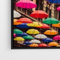 Obraz w ramie 70x50 - Barwna symfonia wyobraźni - fotografia, kolorowe parasolki podwieszone nad ulicą - rama czarna