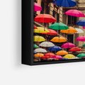Obraz w ramie 50x50 - Barwna symfonia wyobraźni - fotografia, kolorowe parasolki podwieszone nad ulicą - rama czarna
