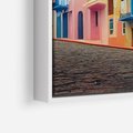 Obraz w ramie 50x70 - Ekspresja marzeń i tęsknot - pastelowe kolorowe budynki, wzdłuż ulicy - rama biała