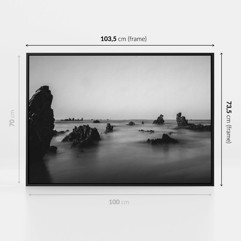 Obraz w ramie 100x70 - Harmonia świateł i cieni - zamglona dzika plaża, skały na plaży - rama czarna