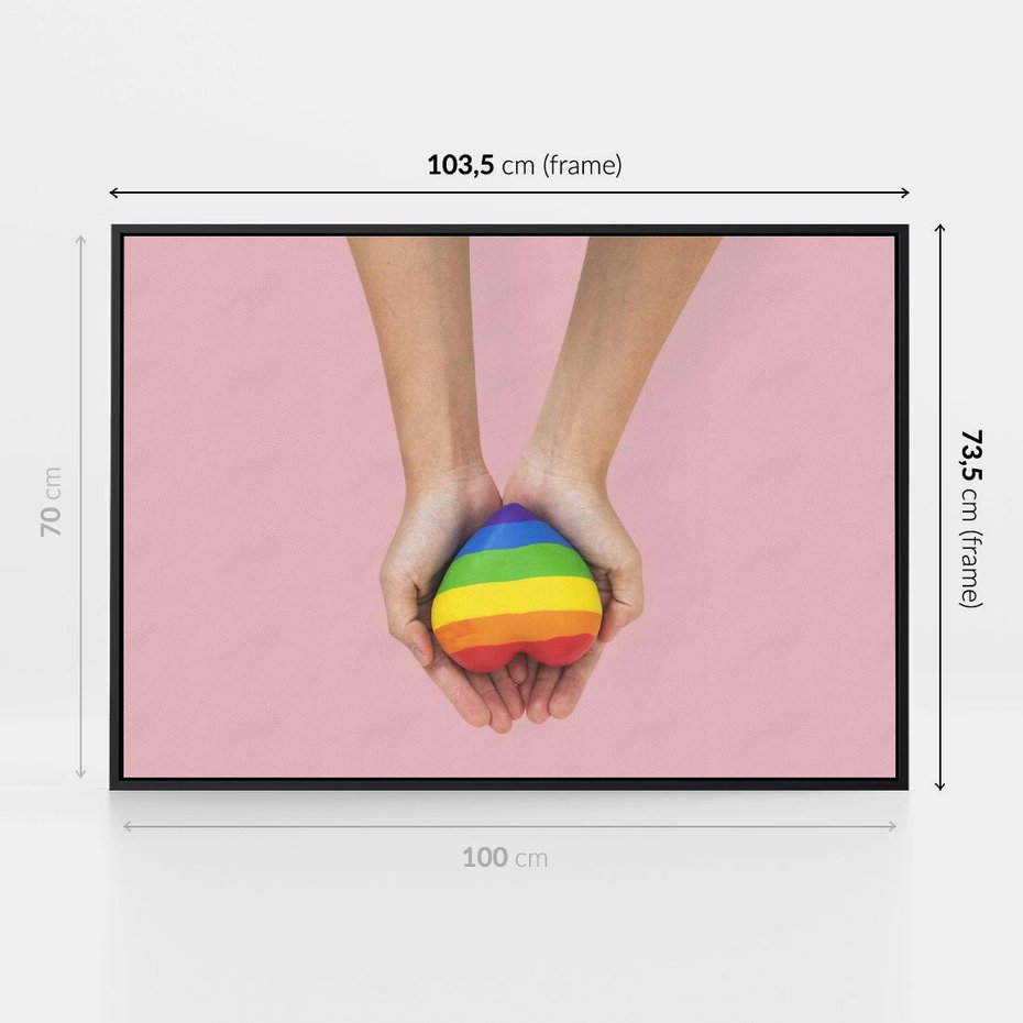 Obraz w ramie 100x70 - Miłość na Dłoniach - zdjęcie, dłonie trzymają ulepione tęczowe serce - rama czarna