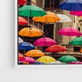Obraz w ramie 80x120 - Barwna symfonia wyobraźni - fotografia, kolorowe parasolki podwieszone nad ulicą - rama biała