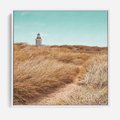 Obraz w ramie 50x50 - Tajemnicza Ścieżka - latarnia morska w oddali, suche trawy - rama biała