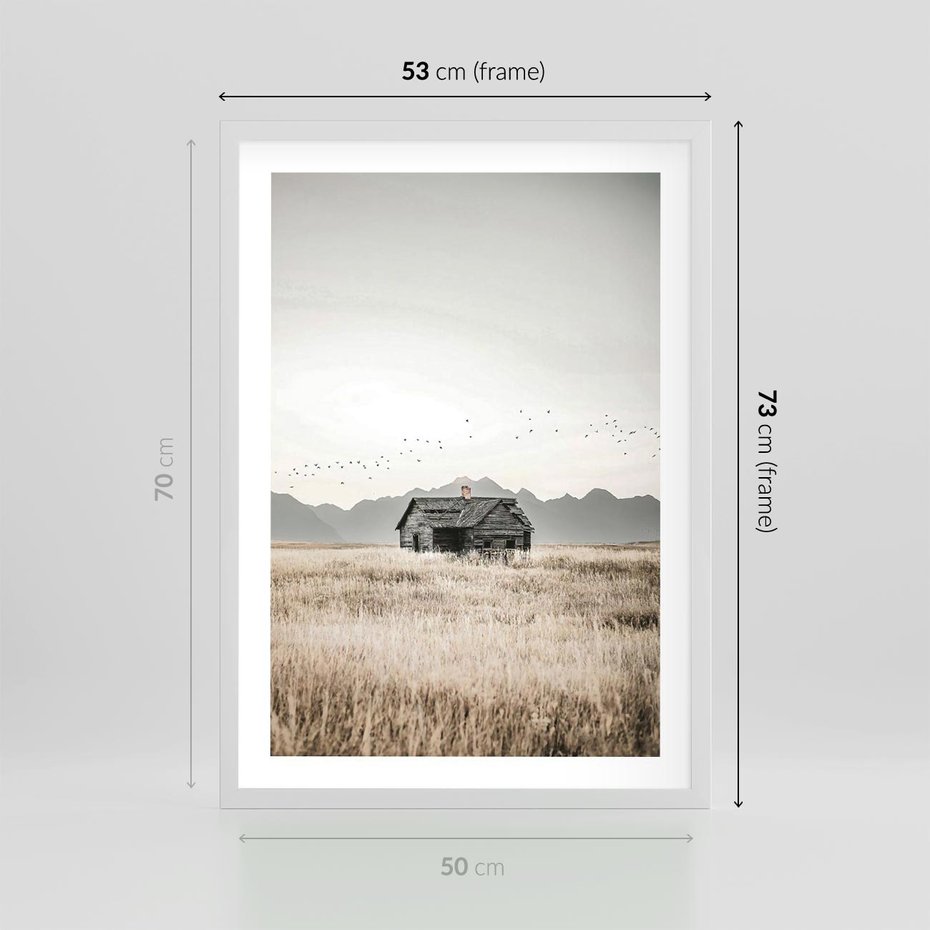 Plakat w ramie 50x70 - Wiejska Idylla - stary drewniany dom w polu suchej trawy, fotografia - rama biała