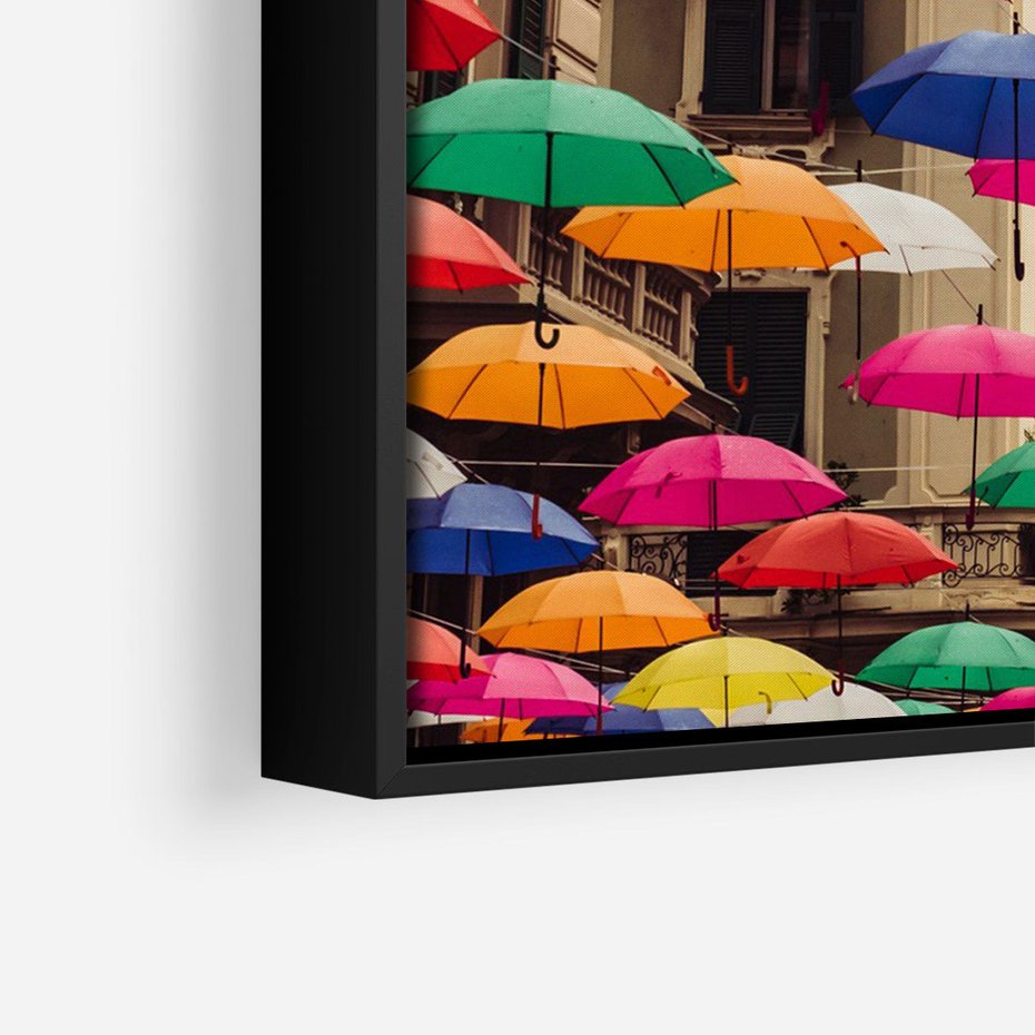 Obraz w ramie 50x70 - Barwna symfonia wyobraźni - fotografia, kolorowe parasolki podwieszone nad ulicą - rama czarna