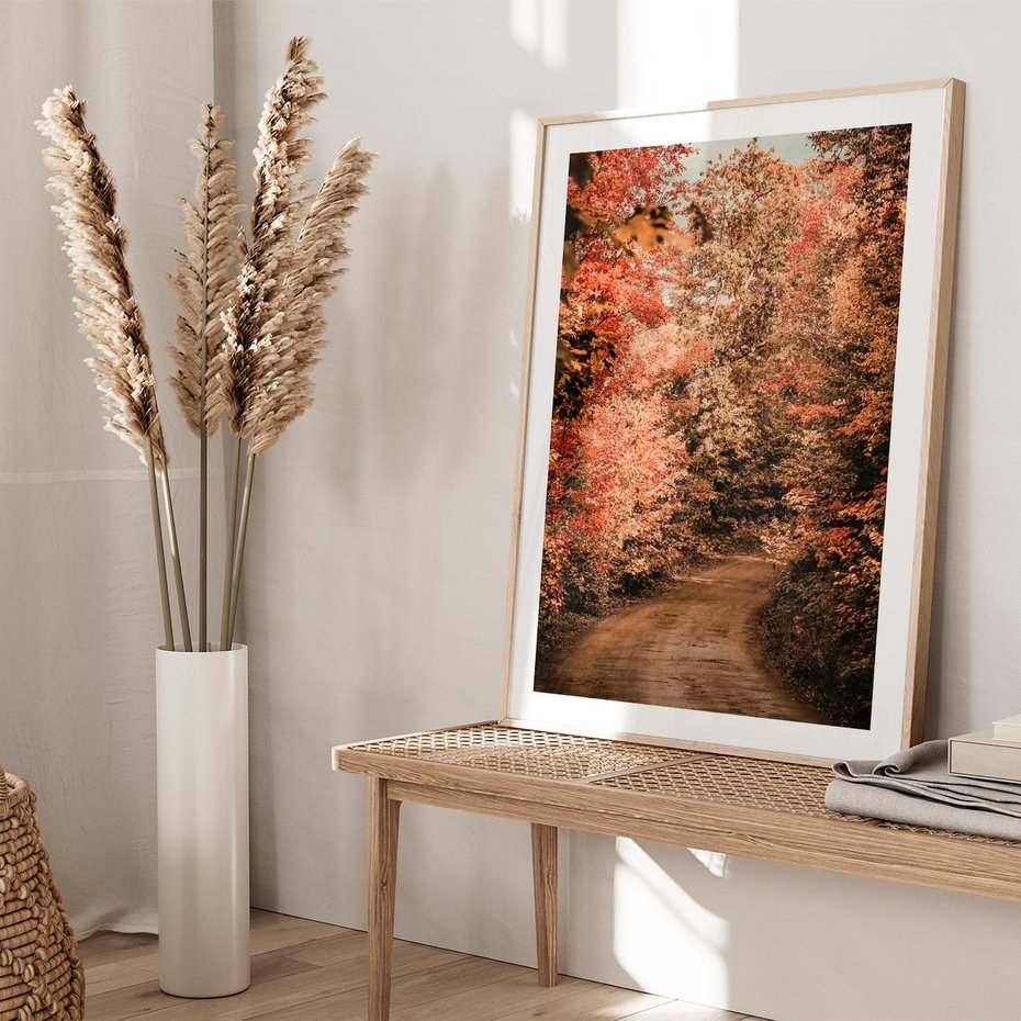 Plakat w ramie 30x40 - Obraz przedstawia jesienne drzewa i czerwone liście na ścieżce w lesie. Ta sceneria doskonale oddaje urok i kolorystykę jesieni w lesie. - las, jesień - rama drewno